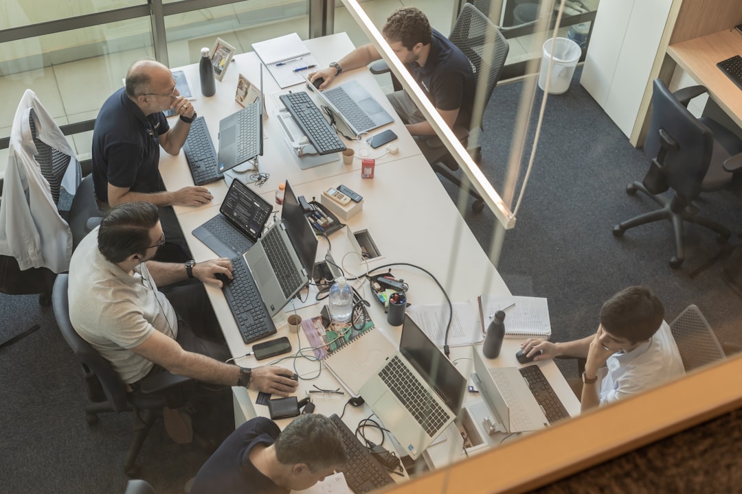 Team of four collaborating at desks in a modern office environment